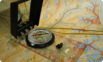 A compass and some wires on top of a map.