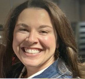 A woman smiling for the camera with long hair.