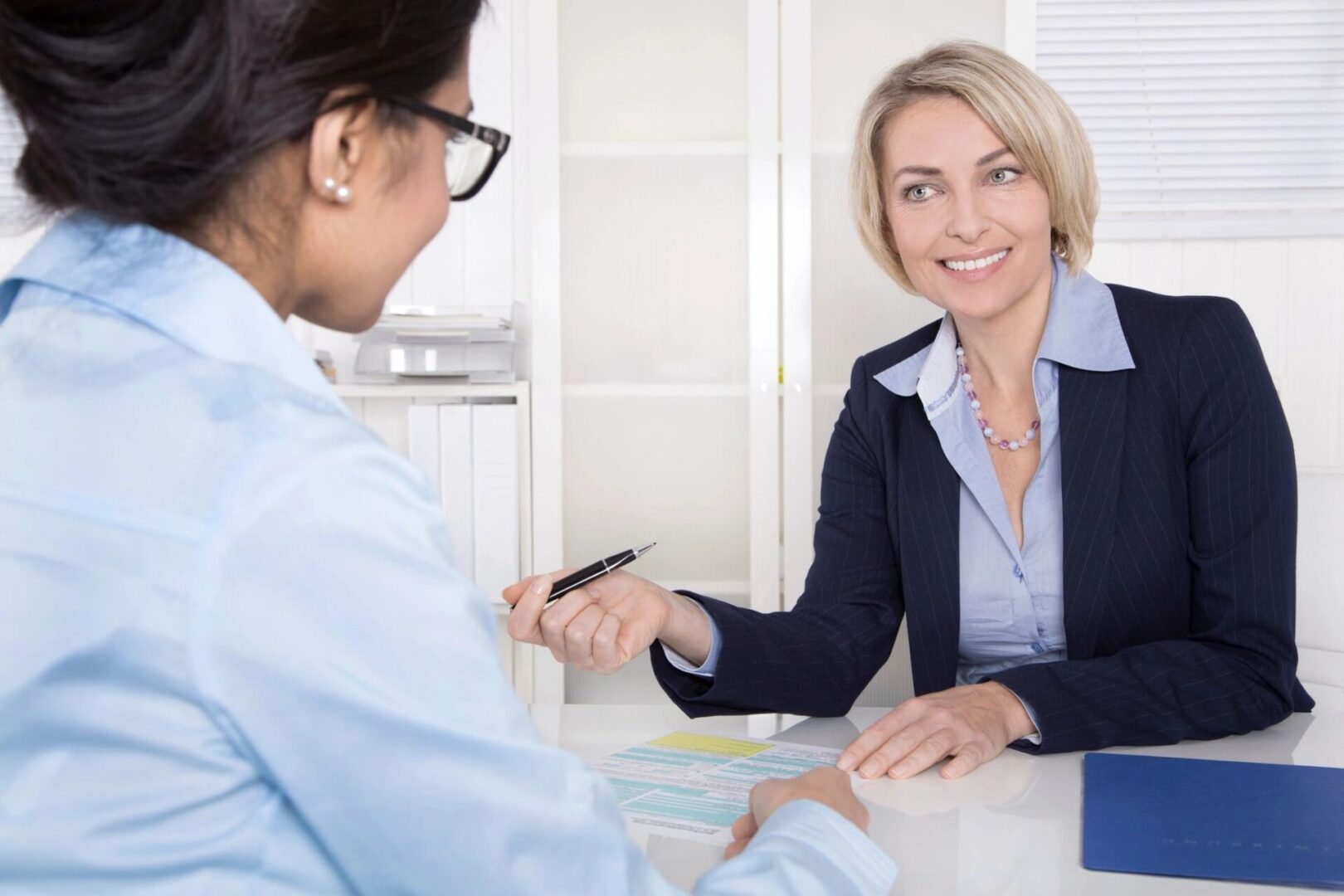 A woman is sitting at the table with another person.